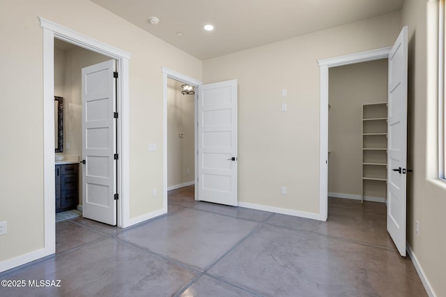 976 W Las Lomitas Rd, Tucson, AZ 85704 - unfurnished bedroom featuring concrete flooring, a walk in closet, recessed lighting, a closet, and ensuite bath