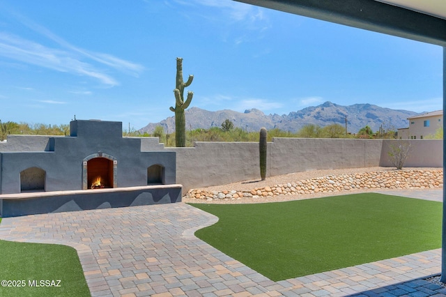 976 W Las Lomitas Rd, Tucson, AZ 85704 - view of yard featuring a warm lit fireplace, a mountain view, and a patio