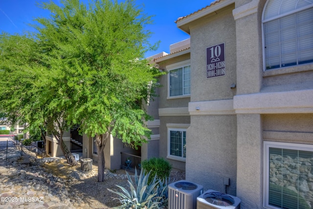 1500 E Pusch Wilderness Dr Unit 10106, Tucson, AZ 85737 - view of side of property with cooling unit and stucco siding