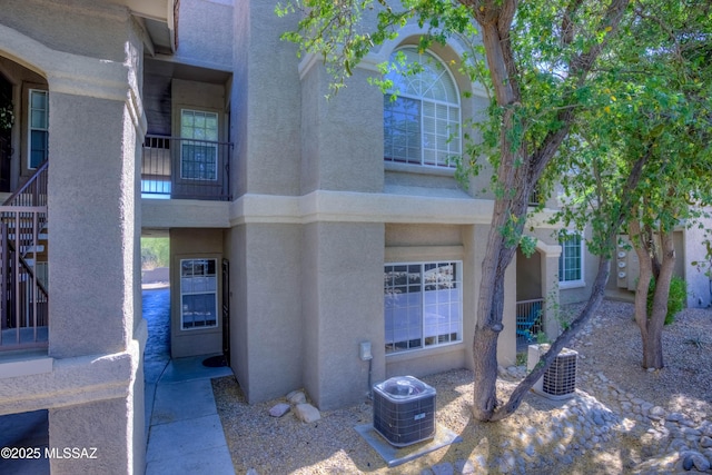 1500 E Pusch Wilderness Dr Unit 10106, Tucson, AZ 85737 - view of front of home featuring stucco siding, central AC unit, and stairway