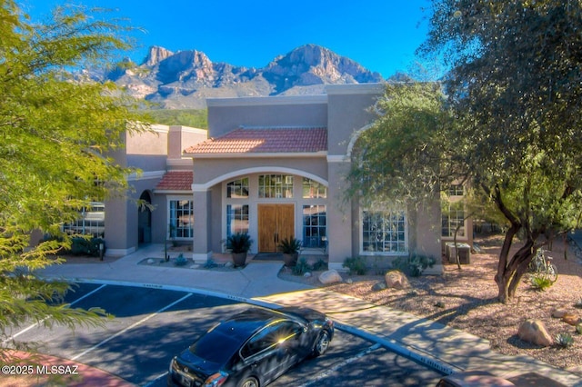1500 E Pusch Wilderness Dr Unit 10106, Tucson, AZ 85737 - view of front of property featuring a mountain view, uncovered parking, stucco siding, and a tile roof