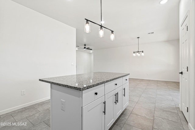 1844 Burns Ct, Rio Rico, AZ 85648 - kitchen with ceiling fan, a kitchen island, stone counters, white cabinets, and pendant lighting