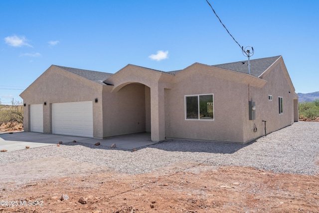 1844 Burns Ct, Rio Rico, AZ 85648 - view of front of home featuring an attached garage, stucco siding, roof with shingles, and concrete driveway