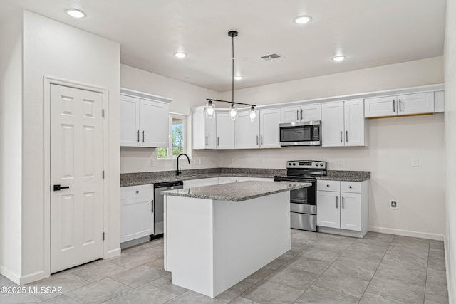 1844 Burns Ct, Rio Rico, AZ 85648 - kitchen featuring appliances with stainless steel finishes, white cabinetry, a sink, a center island, and pendant lighting