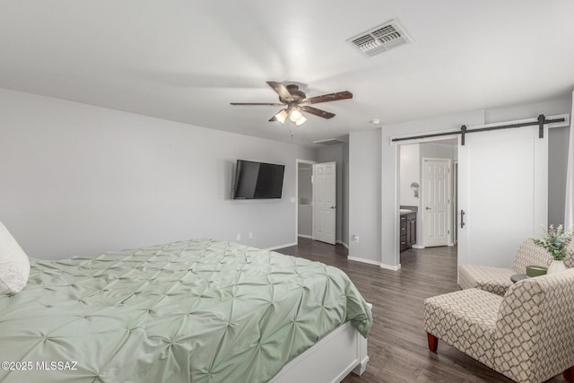 8751 W Saguaro Moon Rd, Marana, AZ 85653 - bedroom with a barn door, dark wood-type flooring, and baseboards