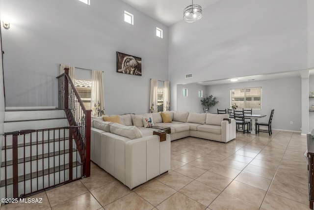 8751 W Saguaro Moon Rd, Marana, AZ 85653 - living area featuring a towering ceiling, light tile patterned flooring, and stairway