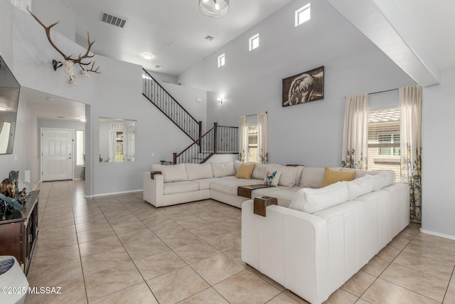 8751 W Saguaro Moon Rd, Marana, AZ 85653 - living room with light tile patterned flooring, a towering ceiling, baseboards, and stairway
