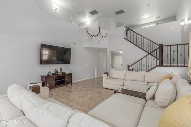 8751 W Saguaro Moon Rd, Marana, AZ 85653 - tiled living area featuring stairway, a high ceiling, and baseboards