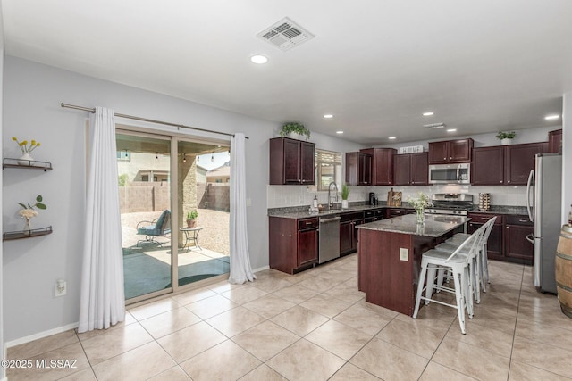 8751 W Saguaro Moon Rd, Marana, AZ 85653 - kitchen with appliances with stainless steel finishes, a center island, a sink, tasteful backsplash, and recessed lighting