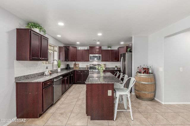 8751 W Saguaro Moon Rd, Marana, AZ 85653 - kitchen with appliances with stainless steel finishes, a sink, tasteful backsplash, a kitchen island, and dark stone counters
