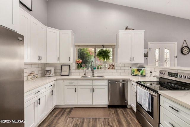 4522 W Vander Bie Pl, Tucson, AZ 85741 - kitchen with appliances with stainless steel finishes, a sink, white cabinets, decorative backsplash, and vaulted ceiling
