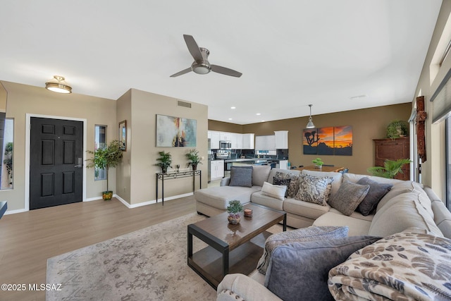 37671 S Hill Side Dr, Tucson, AZ 85739 - living area featuring light wood-style flooring, a ceiling fan, baseboards, healthy amount of natural light, and recessed lighting