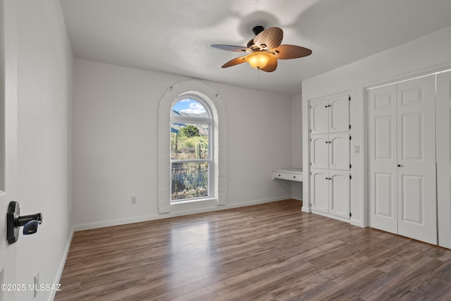 6355 N Camino De Santa Valera, Tucson, AZ 85718 - unfurnished bedroom featuring wood finished floors, baseboards, and a ceiling fan