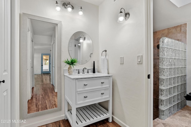 6355 N Camino De Santa Valera, Tucson, AZ 85718 - bathroom with vanity, a walk in shower, wood finished floors, and baseboards