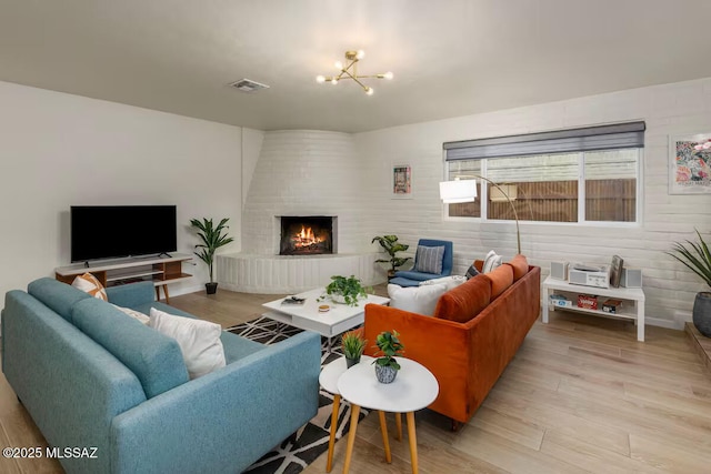 5601 E Baker St, Tucson, AZ 85711 - living area with a brick fireplace, light wood-style floors, and a chandelier