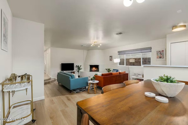 5601 E Baker St, Tucson, AZ 85711 - dining room featuring a fireplace, wood finished floors, and baseboards