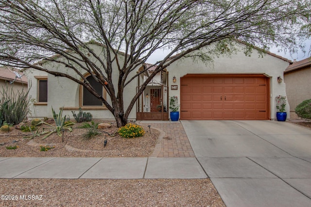 5457 S Canyon Oak Dr, Tucson, AZ 85747 - view of front facade featuring stucco siding, driveway, and a garage