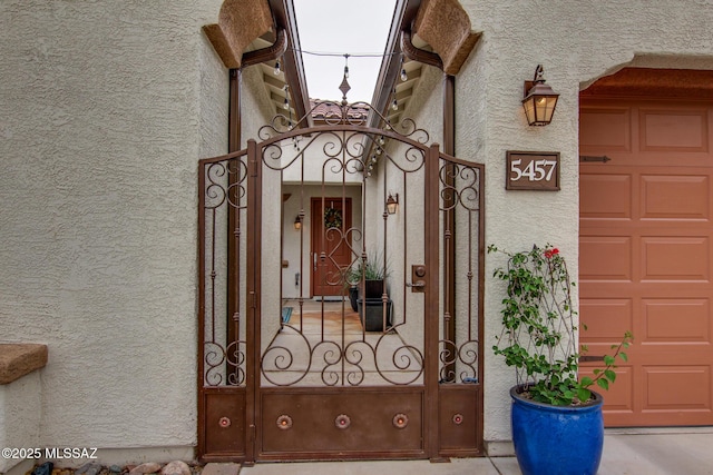 5457 S Canyon Oak Dr, Tucson, AZ 85747 - doorway to property featuring stucco siding, a gate, and a garage