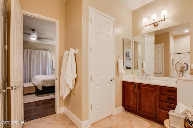 5457 S Canyon Oak Dr, Tucson, AZ 85747 - ensuite bathroom with vanity, tile patterned flooring, baseboards, and ceiling fan