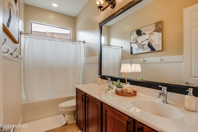 5457 S Canyon Oak Dr, Tucson, AZ 85747 - full bathroom featuring toilet, double vanity, shower / bath combo with shower curtain, wainscoting, and tile patterned floors