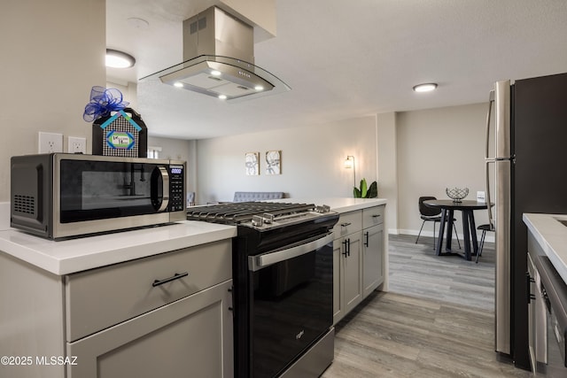 425 W Paseo Redondo Unit 3D, Tucson, AZ 85701 - kitchen with stainless steel appliances, island range hood, light wood-style flooring, light countertops, and gray cabinetry