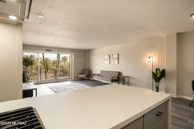 425 W Paseo Redondo Unit 3D, Tucson, AZ 85701 - kitchen with a textured ceiling, light countertops, dark wood-style flooring, open floor plan, and gray cabinetry