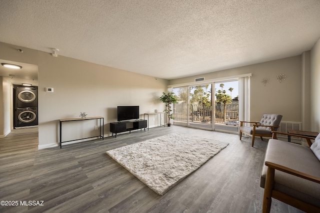 425 W Paseo Redondo Unit 3D, Tucson, AZ 85701 - living room with stacked washer and clothes dryer, wood finished floors, a textured ceiling, and baseboards