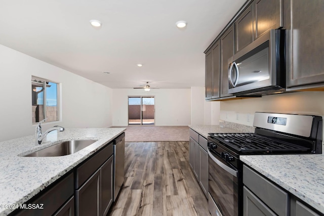 21945 E Wayward Ln, Red Rock, AZ 85145 - kitchen with appliances with stainless steel finishes, ceiling fan, light stone counters, light wood-type flooring, and recessed lighting