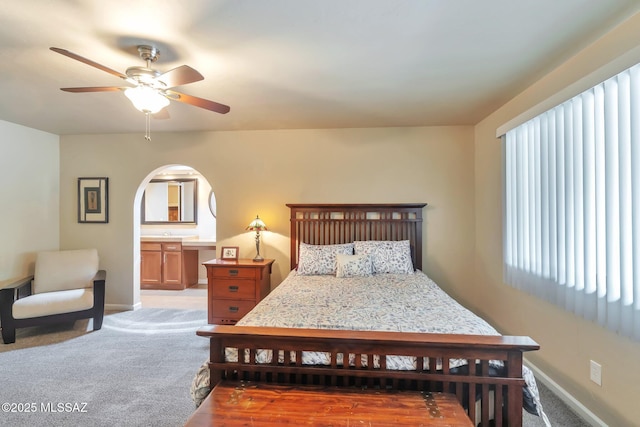 2435 N Shade Tree Cir, Tucson, AZ 85715 - bedroom featuring light carpet, baseboards, a ceiling fan, and arched walkways