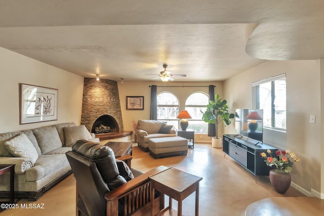 2435 N Shade Tree Cir, Tucson, AZ 85715 - living room featuring a ceiling fan, baseboards, a fireplace, and concrete floors