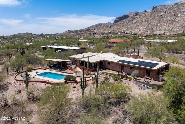 6731 N Pontatoc Rd, Tucson, AZ 85718 - back of property with a mountain view, a patio area, solar panels, and a chimney