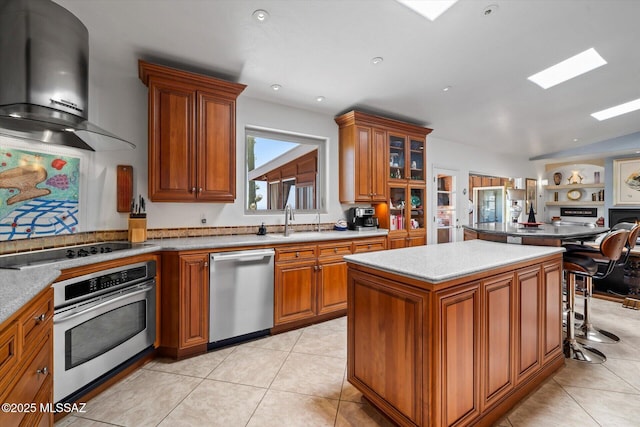 6731 N Pontatoc Rd, Tucson, AZ 85718 - kitchen with stainless steel appliances, wall chimney exhaust hood, brown cabinets, a center island, and a sink
