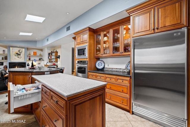 6731 N Pontatoc Rd, Tucson, AZ 85718 - kitchen featuring stainless steel appliances, a center island, brown cabinets, and open floor plan