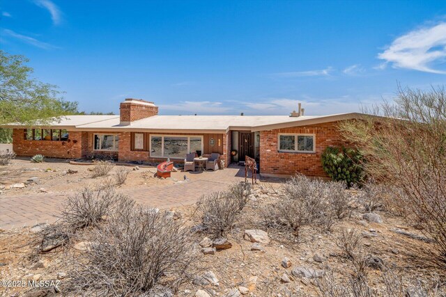 6731 N Pontatoc Rd, Tucson, AZ 85718 - rear view of house featuring brick siding, a chimney, and a patio area