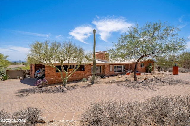 6731 N Pontatoc Rd, Tucson, AZ 85718 - view of front of home with a chimney and brick siding
