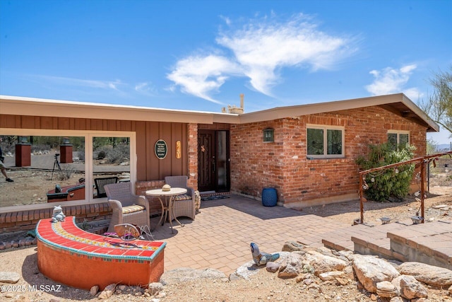 6731 N Pontatoc Rd, Tucson, AZ 85718 - rear view of house with a patio area, board and batten siding, and brick siding