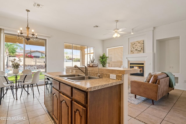246 W Tabascoe Pl, Oro Valley, AZ 85755 - kitchen with a sink, light tile patterned floors, a fireplace, a ceiling fan, and light countertops