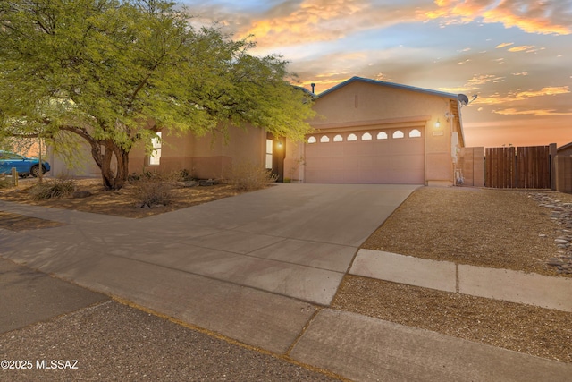 3347 S Desert Scroll Pl, Tucson, AZ 85735 - view of front of property featuring concrete driveway, stucco siding, an attached garage, and a gate