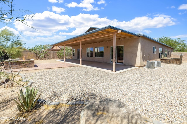 3347 S Desert Scroll Pl, Tucson, AZ 85735 - back of property with a patio area, a fire pit, cooling unit, and stucco siding