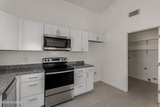 8072 S Carbury Way, Tucson, AZ 85747 - kitchen with stainless steel appliances, white cabinets, baseboards, and dark stone counters