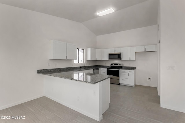 8072 S Carbury Way, Tucson, AZ 85747 - kitchen featuring stainless steel appliances, a peninsula, white cabinets, dark stone countertops, and baseboards