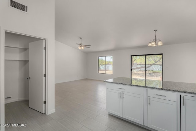8072 S Carbury Way, Tucson, AZ 85747 - kitchen featuring a chandelier, a ceiling fan, white cabinets, light stone countertops, and pendant lighting
