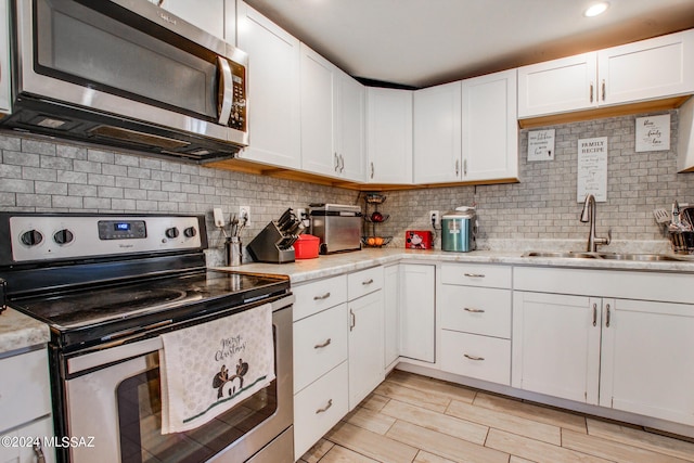 3758 E Ellington Pl, Tucson, AZ 85713 - kitchen with stainless steel appliances, a sink, light countertops, and white cabinetry