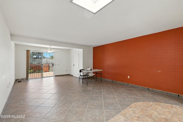 1358 S Desert Meadows Cir, Green Valley, AZ 85614 - empty room with an accent wall, brick wall, tile patterned flooring, and a ceiling fan