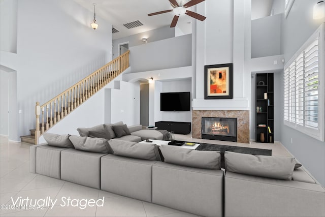 9422 N Weather Hill Dr, Tucson, AZ 85743 - living area with high vaulted ceiling, ceiling fan, stairway, light tile patterned flooring, and a premium fireplace