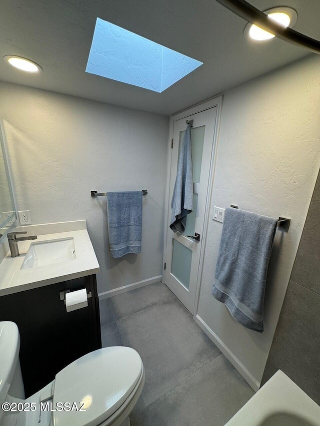 516 E Linden St, Tucson, AZ 85705 - bathroom featuring toilet, vanity, a skylight, and baseboards