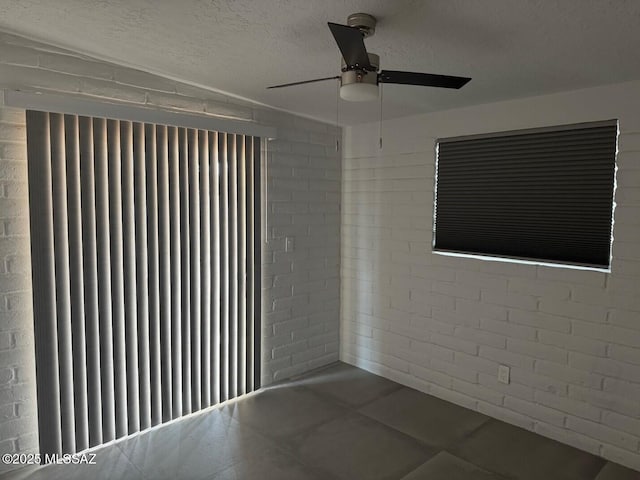 516 E Linden St, Tucson, AZ 85705 - spare room with a ceiling fan, a textured ceiling, and brick wall