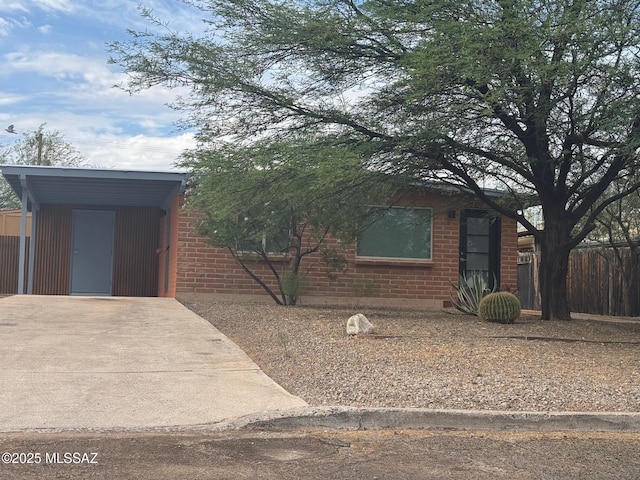 516 E Linden St, Tucson, AZ 85705 - view of front of home featuring a carport, brick siding, and concrete driveway