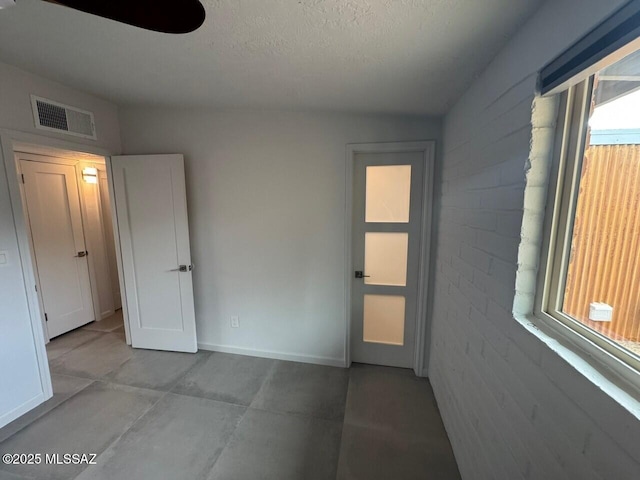 516 E Linden St, Tucson, AZ 85705 - empty room featuring plenty of natural light, a textured ceiling, and baseboards