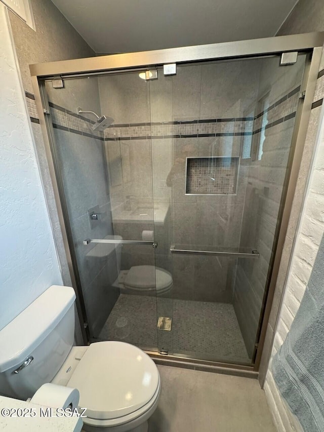 516 E Linden St, Tucson, AZ 85705 - bathroom featuring toilet, a shower stall, and a textured wall